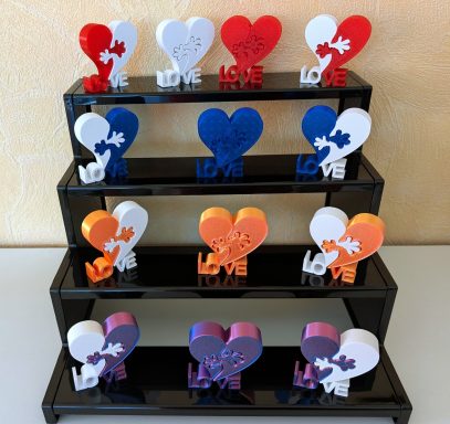 Bunte Herzen auf einer schwarzen Ständer, beschriftet mit "LOVE".