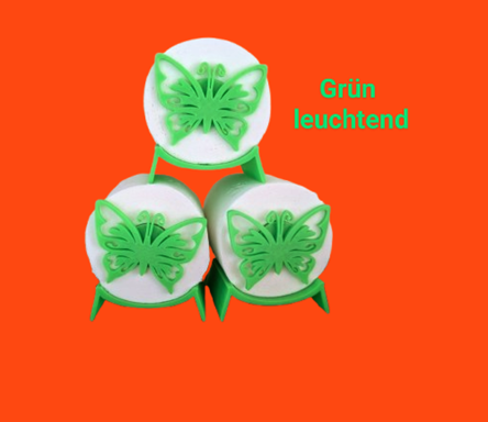 Drei leuchtende grüne Schmetterlinge auf weißen runden Unterlagen vor orangefarbigem Hintergrund.