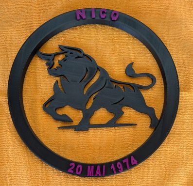 Schwarzes Emblem eines Stiers mit dem Namen "NICO" und dem Datum "20 MAI 1974".